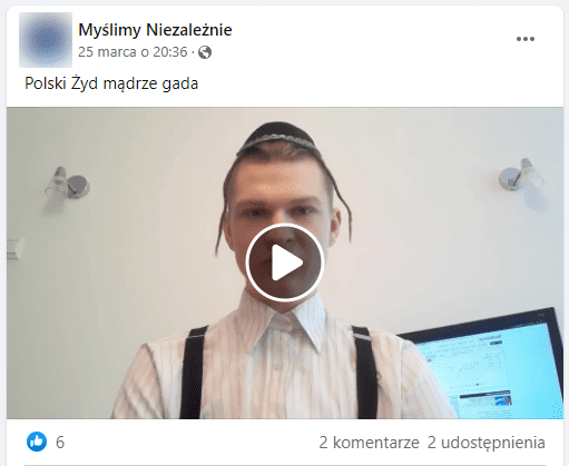 Zrzut omawianego posta na Facebooku, który udostępnia film. W kadrze widzimy młodego chłopaka z białek koszuli i szelkach. Na głowie ma jarmułkę oraz sztuczne pejsy.