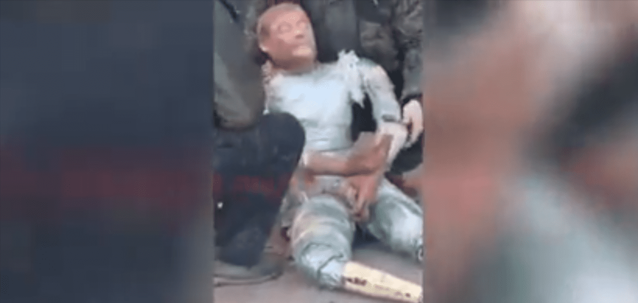 Zrzut ekranu z nagrania, na którym widać manekina owiniętego taśmą.
