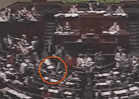 Zrzut ekranu z nagrania posiedzenia Sejmu przedstawiający moment, w którym posłowie głosowali „przeciw” odwołaniu rządu Jana Olszewskiego. Zaznaczony jest Jarosław Kaczyński, który podnosi rękę.
