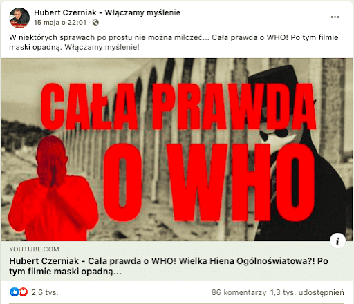 Wpis na Facebooku zawierający link do materiału Huberta Czerniaka o WHO. Widoczna okładka filmu zawiera czarno białe zdjęcie jakiejś konstrukcji. W centralnym punkcie umieszczony został czerwony napis „cała prawda o WHO”. Za napisem, lecz przed konstrukcją widzimy czarną postać, noszącą białą maskę. Obok napisu z lewej strony z kolei stoi czerwony człowiek zasłaniający twarz