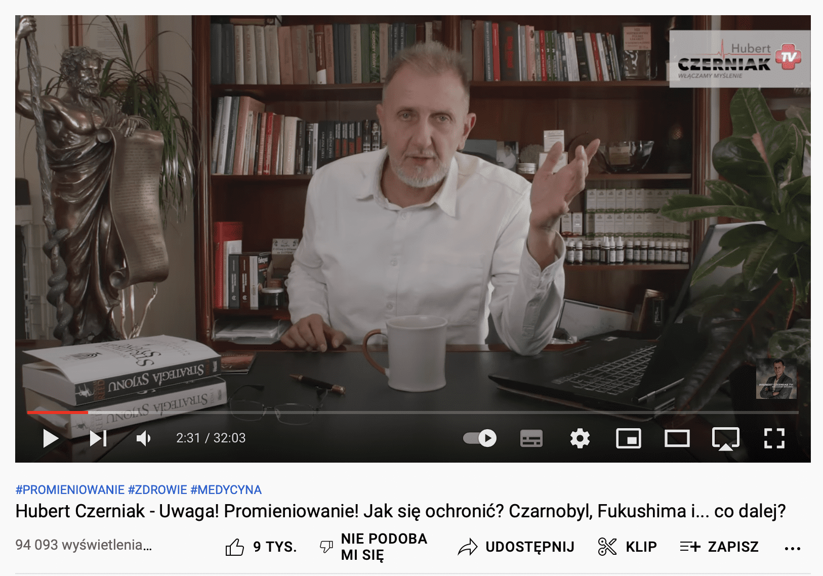 Zrzut ekranu z Youtube'a. Na zdjęciu mężczyzna siedzący za biurkiem.