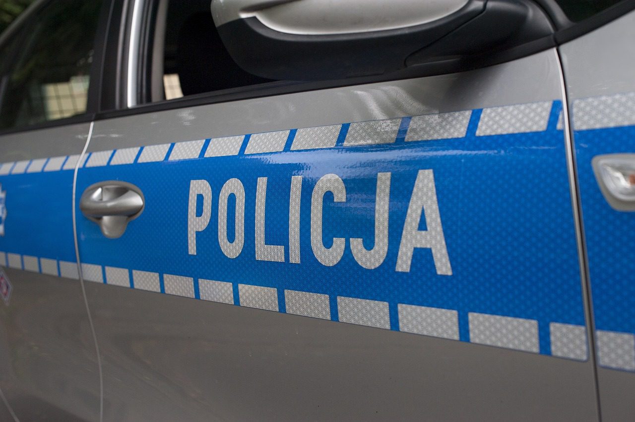 Zdjęcie drzwi od policyjnego radiowozu z napisem Policja