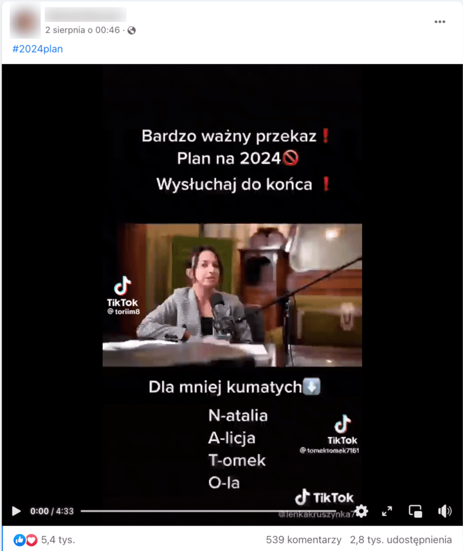 Zrzut ekranu z Facebooka. Na zdjęciu jest siedząca przy stole kobieta, która mówi do mikrofonu. 