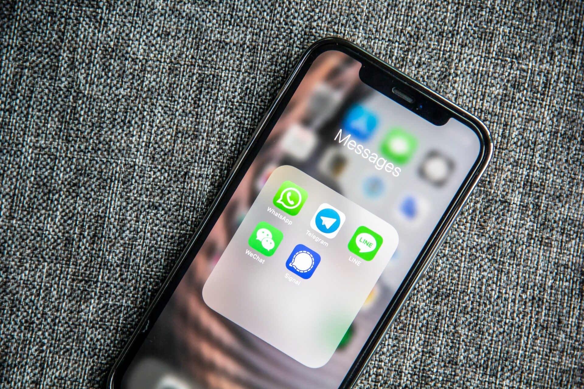 smartfon leżący na tkanym materiale – na smartfonie wyświetlają się ikony komunikatorów