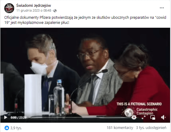 Wpis na Facebooku związany z teorią o tym, że szczepionki przeciw COVID-19 powodują mykoplazmowe zapalenie płuc. W kadrze widać trzy osoby siedzące za stołem na czarnym tle. Wszystkie mają podstawione mikrofony. Kadr ustawiony jest w taki sposób, że widzimy je po skosie. Stół ustawiony na wysokości mostka. Od prawej przy stole siedzi kobieta w czerwonym swetrze, mężczyzna w jasnym garniturze i mężczyzna w ciemnym garniturze z białą maseczką ochronną na twarzy. Na stoliku stoi butelka wody.