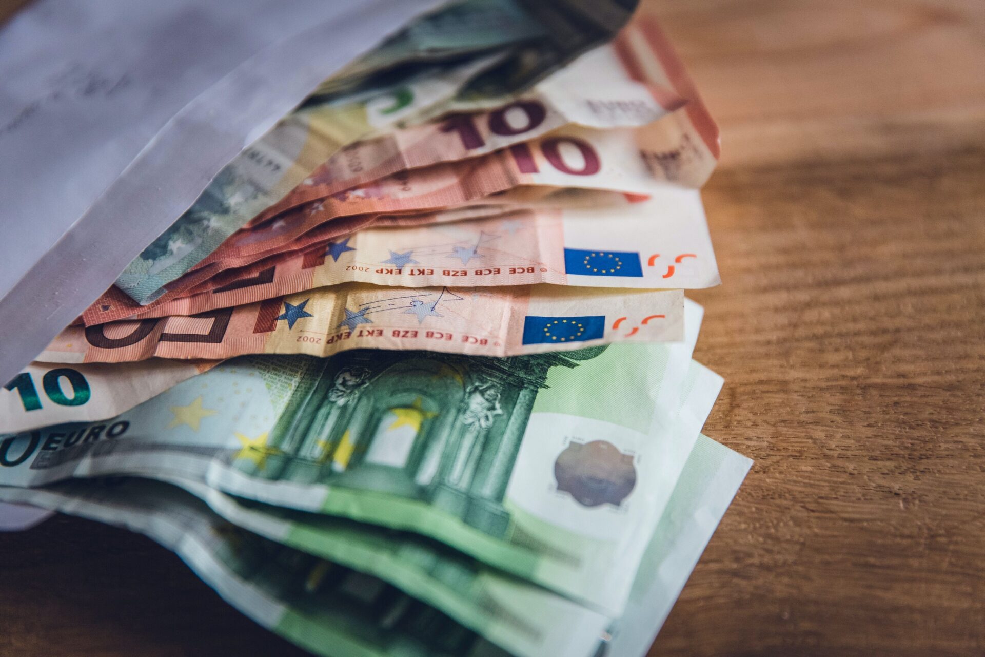 Banknoty euro wysunięte z białej koperty