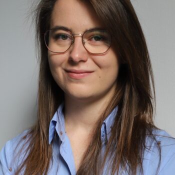 Fotograficzny portret Moniki Stachoń w koszuli na jednolitym tle