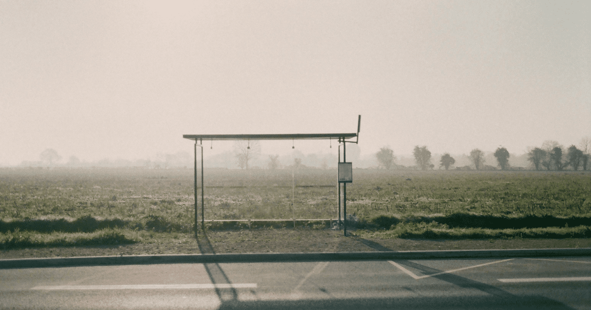 Przystanek autobusowy, w tle widać pole