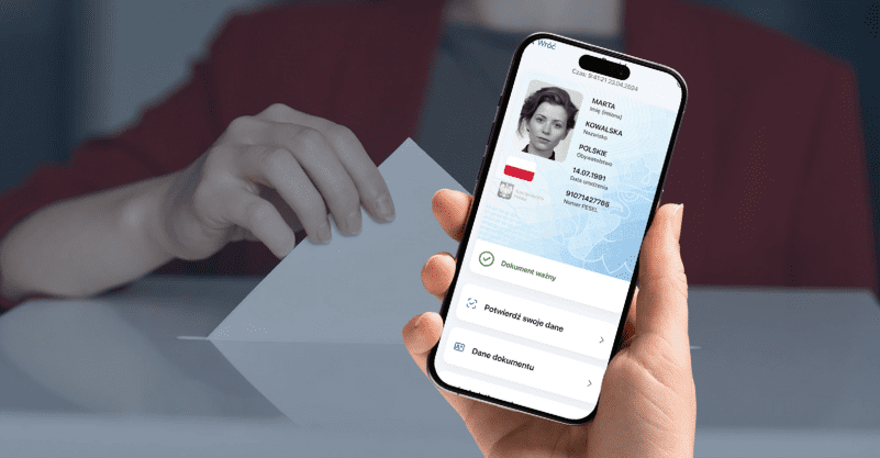 Smartfon z aplikacją mObywatel a w tle ręka wrzucająca głos do urny